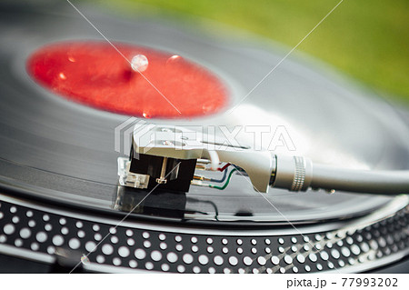 turntable headshell with LP vinyl record, closeup view 77993202