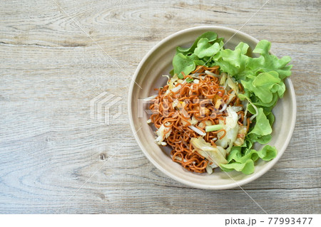 fried instant noodles with cabbage and egg in soybean sauce on bowl fried instant noodles with cabbage and egg in soybean sauce on bowl 77993477
