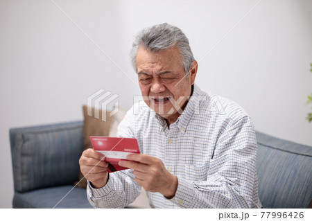 通帳を見て喜ぶシニア男性 77996426