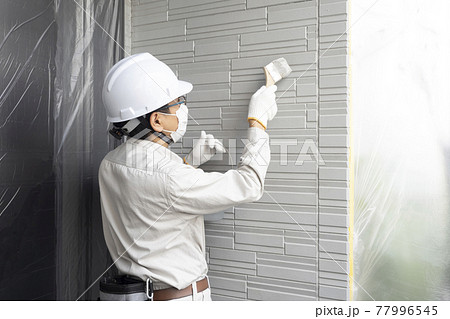 戸建て住宅の外壁を塗る塗装職人 77996545