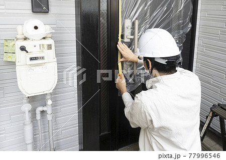 戸建て住宅の養生をする塗装職人 77996546