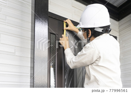 戸建て住宅の養生をする塗装職人 77996561