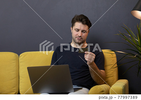 guy makes purchases or payments online, looks at credit card cvv security code 77997389