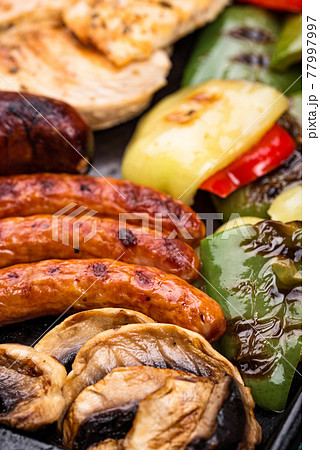 Grilled sausages, meat, and vegetables. 77997997