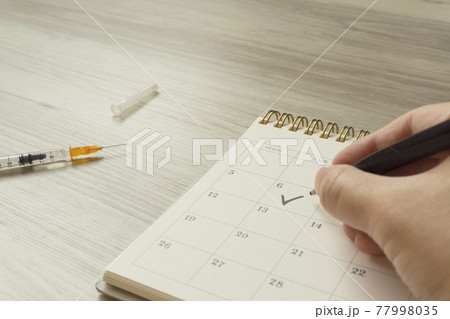 ワクチン接種を受ける。カレンダーと注射器 ワクチン接種を受ける。カレンダーと注射器 77998035