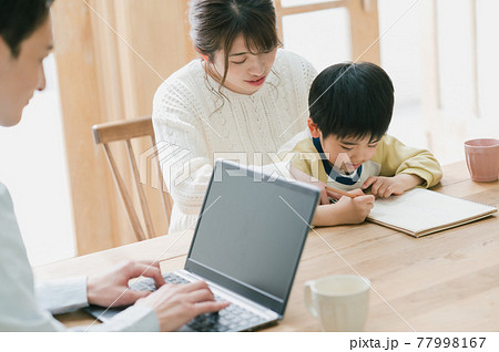 勉強する子供とテレワークする父親 勉強する子供とテレワークする父親 77998167