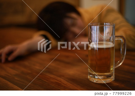 酒を飲み眠る女性 77999226