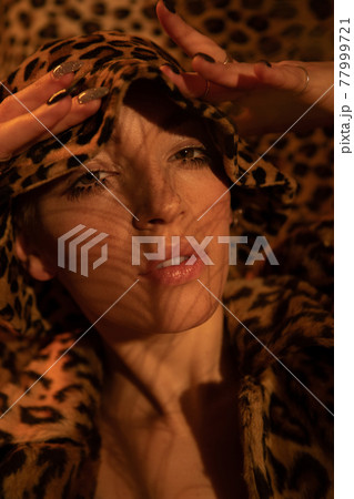 Woman wearing leopard look posing with open mouth and looking at the camera 77999721
