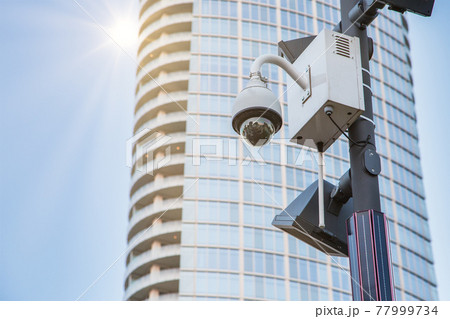 CCTV security camera in public space in urban area 77999734