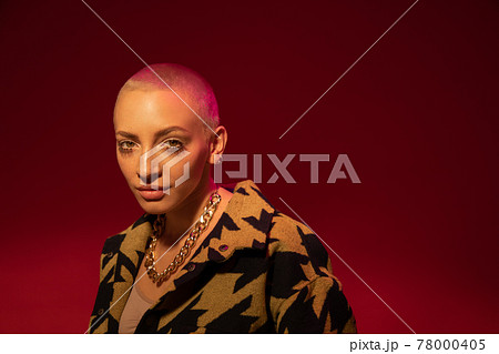 Woman standing and looking at the camera while enjoying pleasant moment in life 78000405