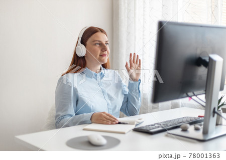 Creative young caucasian business woman working on a digital computer with headphones in the office. Creative young caucasian business woman working on a digital computer with headphones in the office. 78001363
