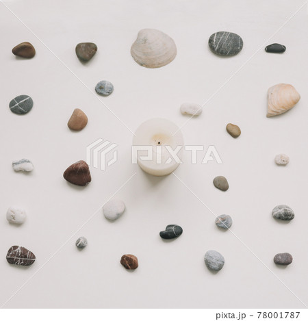 White candle and seashells and stones on white background. Spa concept. Flat lay, top view White candle and seashells and stones on white background. Spa concept. Flat lay, top view 78001787