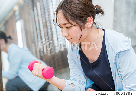 鏡の前でダンベルを使用してトレーニングする女性 鏡の前でダンベルを使用してトレーニングする女性 78001888