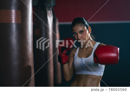 Young Asian doing boxing or Muay Thai punching sandbag in fitness club or gym. healthcare and sport concept. Young Asian doing boxing or Muay Thai punching sandbag in fitness club or gym. healthcare and sport concept. 78003560