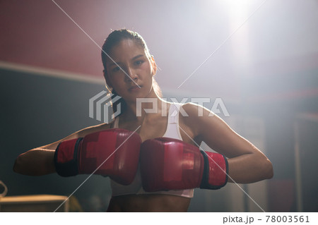 Young Asian doing boxing or Muay Thai punching sandbag in fitness club or gym. healthcare and sport concept. Young Asian doing boxing or Muay Thai punching sandbag in fitness club or gym. healthcare and sport concept. 78003561