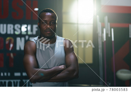 Portrait of African athlete cross arms looking at camera in fitness gym Portrait of African athlete cross arms looking at camera in fitness gym 78003583