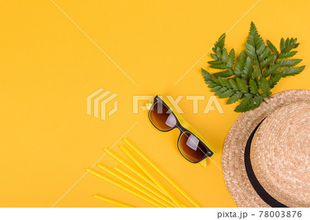 Beach accessories: glasses and hat with shells and sea stars on a colored background 78003876