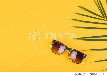 Beach accessories: glasses and hat with shells and sea stars on a colored background Beach accessories: glasses and hat with shells and sea stars on a colored background 78003884