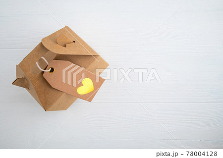 Craft gift box with heart label on white background with space for text. Holiday gift concept. 78004128
