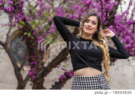 young happy woman in front of beautiful purple flowers 78004836