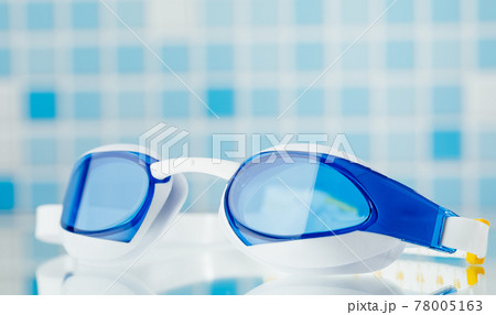 professional swimming glasses for training or competition, blue tile background professional swimming glasses for training or competition, blue tile background 78005163