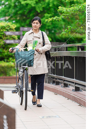 買い物袋を自転車のカゴ(籠)に入れて引いて歩く若い女性 買い物袋を自転車のカゴ(籠)に入れて引いて歩く若い女性 78008574