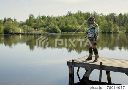 Fisherman catches fish on the lake 78014057