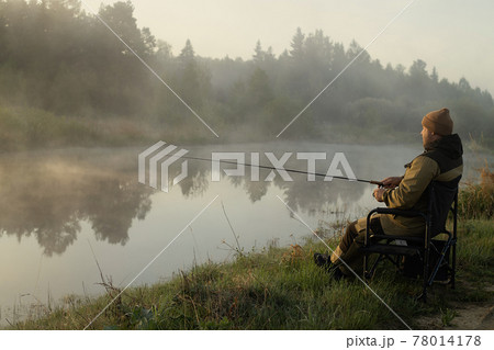Fisherman catches fish on the lake 78014178