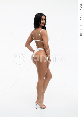 Charming woman with sexy figure in white lingerie looking at camera Charming woman with sexy figure in white lingerie looking at camera 78021478