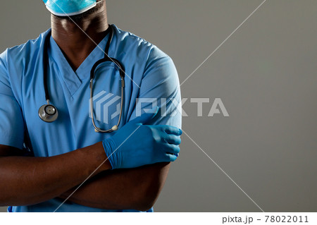 Mid section of african american male health worker with arms crossed against grey background 78022011