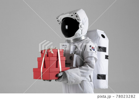 Astronaut holding an event gift box, white background Astronaut holding an event gift box, white background 78023282