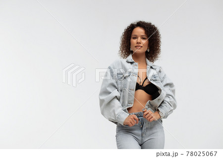 Stylish curly haired woman in denim outfit Stylish curly haired woman in denim outfit 78025067