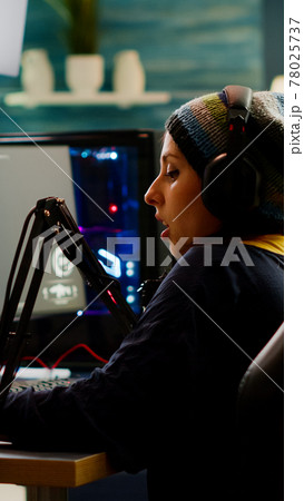 Focused streamer playing shooter game for virtual competition Focused streamer playing shooter game for virtual competition 78025737