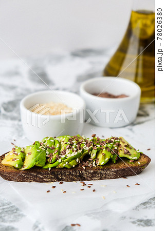 Healthy avocado toast on concrete background. Wholegrain bread, sesame flax seeds olive oil. Vegan keto diet. Healthy eating. Trendy guacamole sandwich Healthy avocado toast on concrete background. Wholegrain bread, sesame flax seeds olive oil. Vegan keto diet. Healthy eating. Trendy guacamole sandwich 78026380