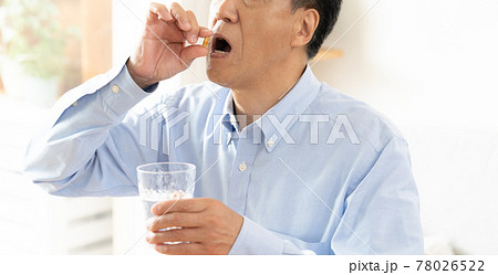 カプセルを服用する中高年男性 78026522
