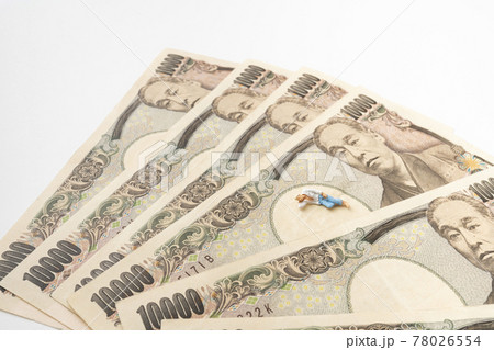 お札の上に寝転ぶミニチュア人形 78026554