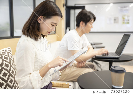コワーキングスペースで端末の操作する女性と男性 78027120