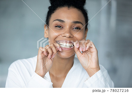 Happy excited millennial Black girl using thin mint thread 78027216