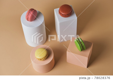 Tasty macarons on trendy geometric pedestals on a beige background Tasty macarons on trendy geometric pedestals on a beige background 78028376