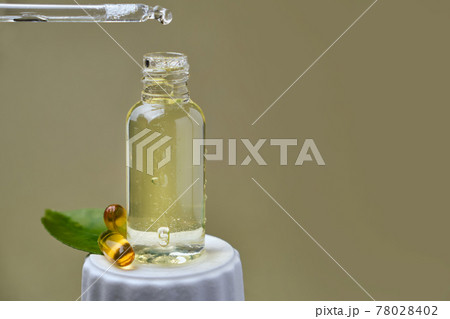 drop of citrus oil close-up macro drips from a pipette into a bottle 78028402