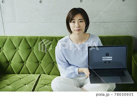 Woman with laptop sitting on sofa. Forgot password Woman with laptop sitting on sofa. Forgot password 78030935
