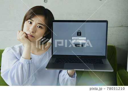 Woman with laptop sitting on sofa. Forgot password 78031210