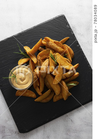 Top view of fried potatos with herbs and sauce. Golden roasted potatoes, fast homemade food. 78034089
