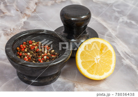 Lemon and stone bowl with peppercorn on gray background. 78036438