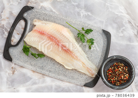 Fillet of raw pangasius fish with spices on cutting board Fillet of raw pangasius fish with spices on cutting board 78036439