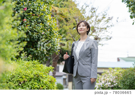 朝、公園を通って出勤する若い女性 78036665