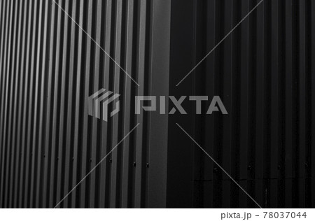 Black corrugated iron sheet used as a facade of a warehouse or factory. Texture of a seamless corrugated zinc sheet metal aluminum facade. Architecture. Metal texture. 78037044
