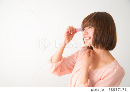 髪の毛先をブラシで梳かす若い女性 髪の毛先をブラシで梳かす若い女性 78037171