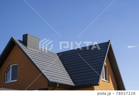 Grey corrugated metal profile roof installed on a modern house. The roof of corrugated sheet. Roofing of metal profile wavy shape. Modern roof made of metal. Metal roofing. 78037226