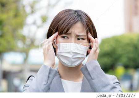 マスク疲れ　マスクに悩む若い女性の顔のアップ 78037277